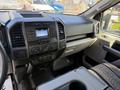 Interior view of a 2018 Ford F-150 showing the dashboard with audio system controls and vents along with a console area