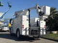 A 2005 Freightliner M2 106 bucket truck with a raised hydraulic lift and work platform at the back for accessing elevated areas