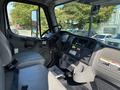 Interior view of a 2019 Freightliner M2 106 showing the driver's seat dashboard and controls with a steering wheel and various instruments