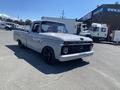 A 1962 Ford 2WHDR pickup truck in gray with a sleek design black wheels and red interior accents
