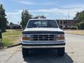 A 1995 Ford F-250 is shown from the front with a white exterior and chrome grille showcasing its classic truck design