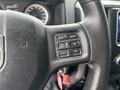 Close-up of the steering wheel of a 2013 RAM 1500 showing control buttons for cruise control settings and a key fob hanging from the ignition