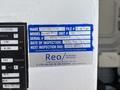 A blue inspection sticker attached to a white surface with details about a vehicle including make model serial number and inspection date