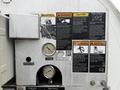 A close-up view of the control panel on a 2013 International Workstar 7500 featuring various warning and caution labels gauges and a grease point