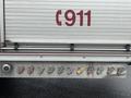 A panel of colorful valves and nozzles on a fire truck with the number 911 prominently displayed in red