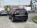 A black 2014 Honda CR-V seen from the rear with a sleek design and prominent tail lights