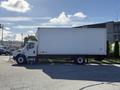 A white 2012 Freightliner M2 106 box truck parked at an angle with a large cargo area and visible front wheels