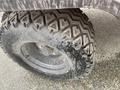 A close-up view of a rugged tire mounted on a wheel with a tread pattern designed for off-road driving on a 2010 Kubota RTV 900
