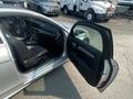 A silver 2013 Mercedes-Benz C-Class with an open driver's door revealing the interior and seating