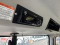 A car stereo unit mounted on the ceiling featuring a digital display and knobs for adjusting volume and settings