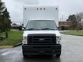A white 2024 Ford E-450 truck facing forward with a large white box cargo area on the back and visible headlights and grille