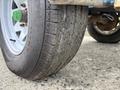 Close-up of a tire from a 2016 Genie TZ-34/20 with a textured tread pattern and a green valve stem