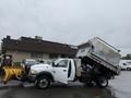A 2011 Dodge Ram 5500 with a dump bed raised and a snow plow attached in the front