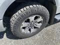 A close-up view of a 2014 Ford F-150 tire showcasing the rugged tread and alloy wheel design