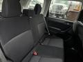 Interior view of the back seat of a 2016 Subaru Forester with black fabric upholstery and seat belts visible