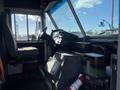Interior view of a 2012 Ford Econoline with a driver's seat visible and dashboard featuring controls and gauges