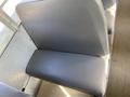 A gray school bus seat with a smooth surface and simple design located inside a Thomas Saf-T-Liner HDX