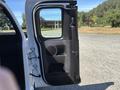 A white 2011 Chevrolet Colorado with the driver's side door open showcasing the interior's door panel and speaker