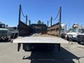 2007 Freightliner M2 106 flatbed truck with a metal bed and side rails facing forward