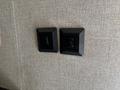 Two black light switches mounted on a textured beige wall