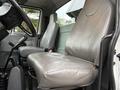 Interior of a 2006 International 4200 featuring two gray leather seats and gear shifter in the foreground