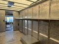 Interior view of a 2018 Ford Econoline showing empty shelving units and a flat floor with metal walls and a ceiling
