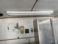 A 2008 Wells Industries Inc EW1422 overhead fluorescent light fixture mounted on a ceiling