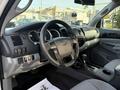 Interior view of a 2013 Toyota Tacoma featuring a steering wheel dashboard gear shift and fabric seats in grey tones