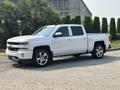 A white 2017 Chevrolet Silverado 1500 pickup truck with chrome accents and alloy wheels parked on a concrete surface