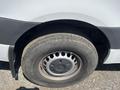 A close-up view of the wheel and tire of a 2022 Mercedes-Benz Sprinter showing a silver rim with circular holes and a worn black tire