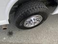 A close-up of a chrome wheel and tire from a 2022 GMC Savana showcasing a rugged tread pattern