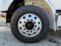 A close-up of a polished chrome truck wheel with a Goodyear tire showcasing its deep treads and multiple lug nut openings