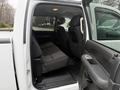 Interior of a 2013 Chevrolet Silverado 3500HD showing the back seat area with a foldable bench seat and door open
