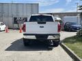 White 2021 Ford F-150 truck viewed from the rear with a chrome bumper and tailgate featuring the Ford logo