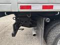 A 2014 Ford F-550 showing a rear hitch assembly with a black mounting bracket and a silver exhaust pipe visible beside a large tire