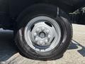 Close-up of a wheel and tire from a 2012 Ford Econoline showing six lug nuts and a silver wheel rim