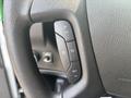 Close-up of the steering wheel controls of a 2021 Chevrolet Express including buttons for resume set and other functions