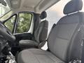 Interior of a 2023 RAM Promaster 3500 with two cloth-covered front seats and a steering wheel visible in the foreground