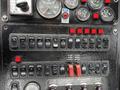 Control panel of a 2013 International DuraStar 4300 featuring various switches and gauges for operational controls