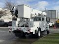 A 2011 International 4300 bucket truck with a white exterior features an elevated work platform and rear-mounted equipment for utility maintenance