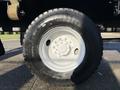 A close-up of a 2015 Hino 358 truck tire featuring a white rim and a large black tire with deep treads and visible bolt patterns