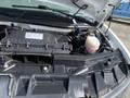 Under the hood of a 2022 GMC Savana showing the engine components and a transparent reservoir filled with liquid