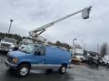 A blue 2006 Ford Econoline van with a raised bucket lift attached to the roof