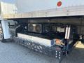Underneath a 2022 Lion Lion6 truck showing the cooling system with two fans and a large metal plate for thermal management