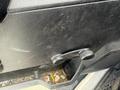 Close-up of the door panel of a 2016 RAM 5500 showing a textured black surface and a manual window crank with debris visible in the lower compartment