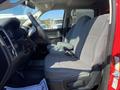 Interior view of a red 2015 RAM 2500 featuring gray cloth seats and a black dashboard with steering wheel and control panel visible