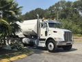 A white 2008 Peterbilt 340 truck with a large silver tank attached to the back and multiple orange lights on the cab