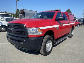 A red 2015 RAM 2500 pickup truck with a black front grille and a white stripe along the side