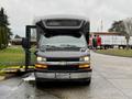 A 2020 Chevrolet Express van with an open side door, showcasing a black exterior and prominent Chevrolet emblem on the front grille