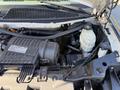 A close-up view of the engine compartment of a 2019 Chevrolet Express showing various mechanical components including the Vortec engine and fluid reservoirs